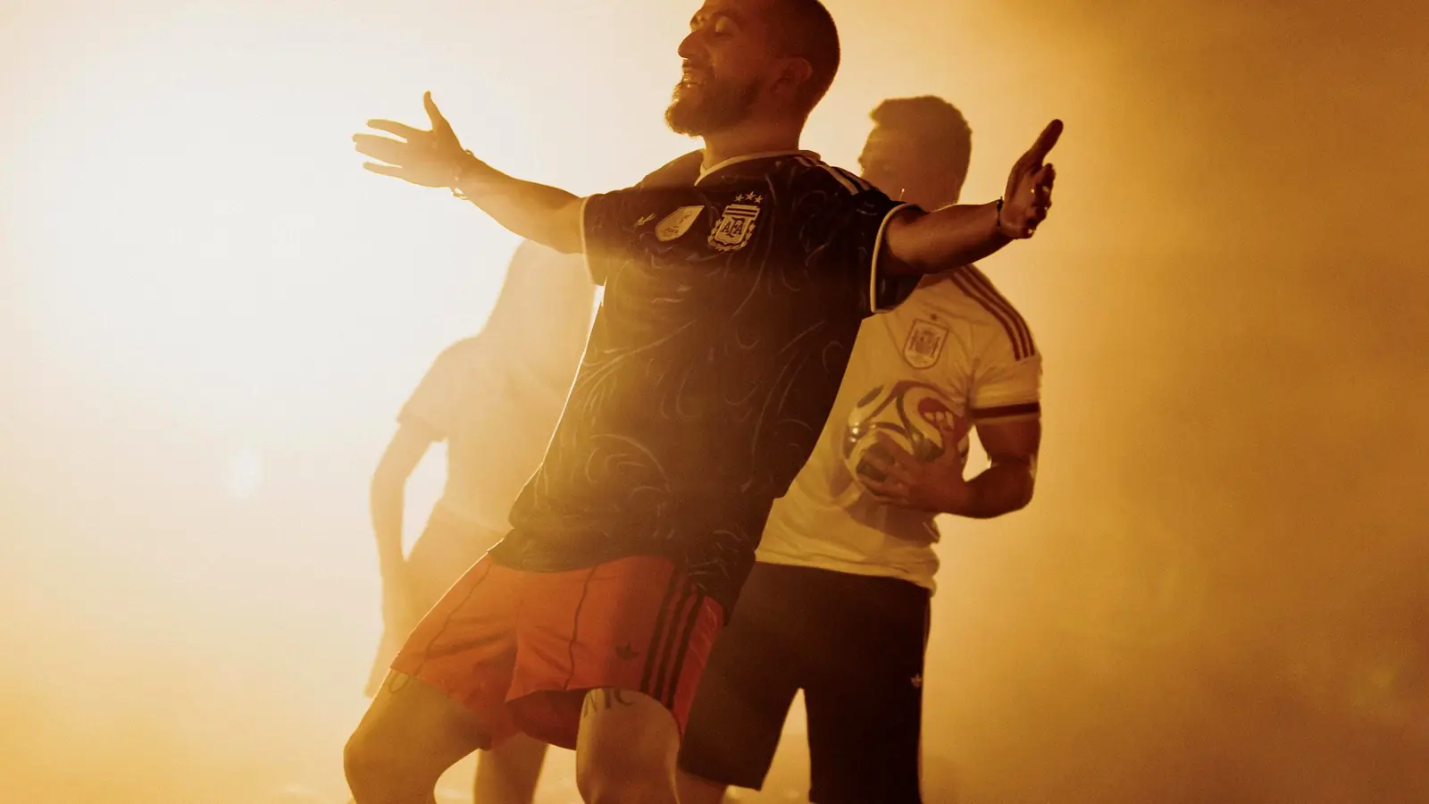 Two players in the away kit, arms wide in golden haze