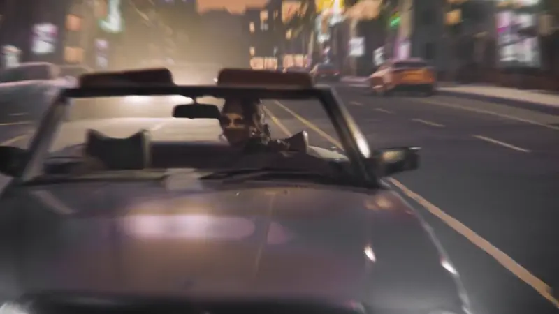 A model in GUESS eyewear in a convertible at night