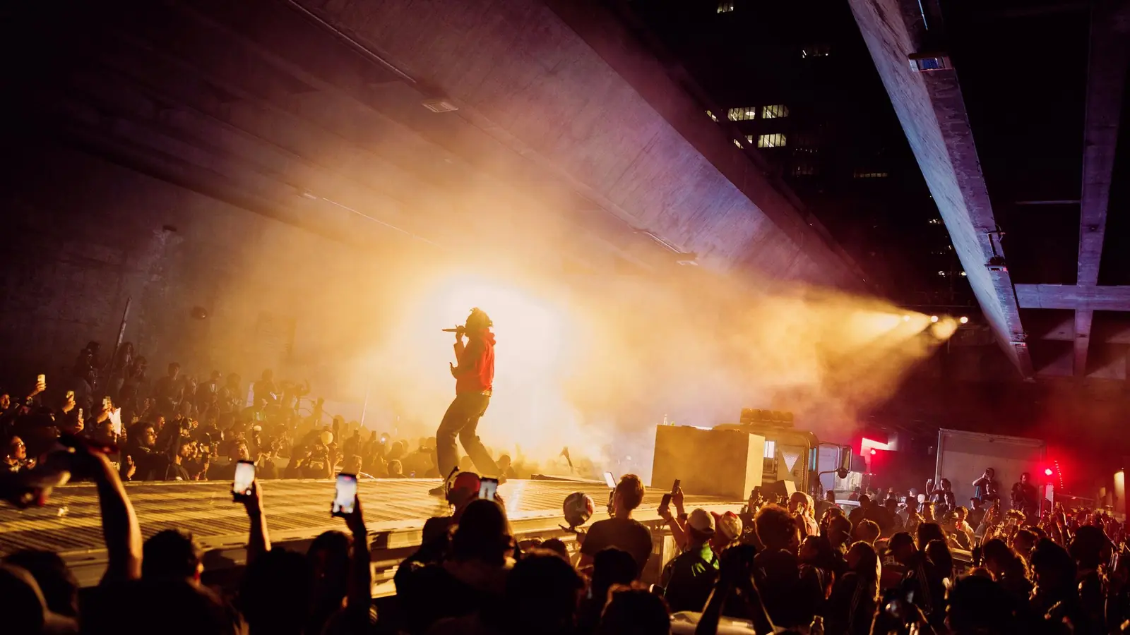 A performer on stage under the freeway at the adidas WC26 Away Kit launch night