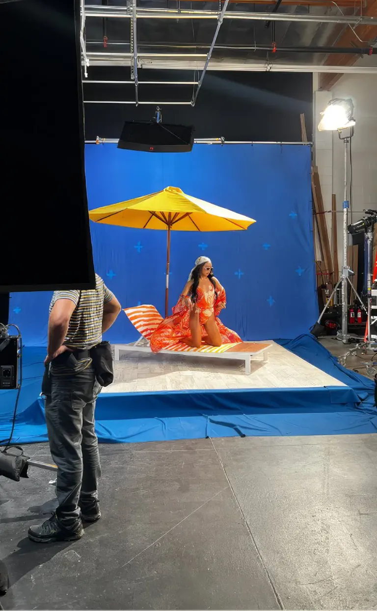 A GUESS shoot in progress on a studio stage, a crew member watching from the foreground