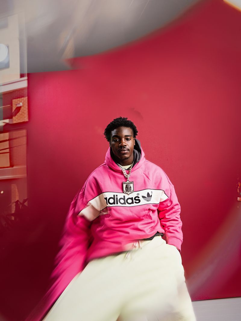 Nick Marsh in a pink adidas hoodie on a red set, shot with in camera motion