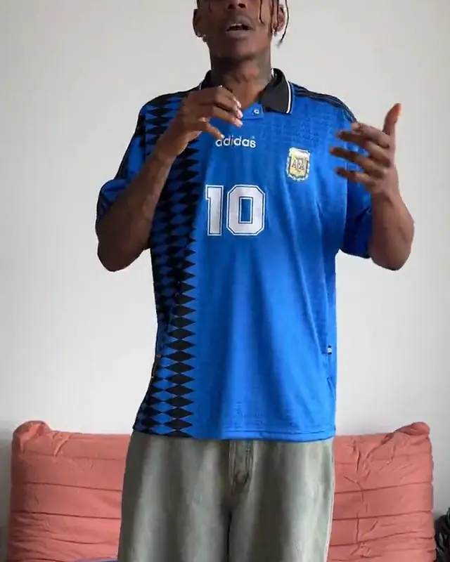 A creator in an adidas football shirt talking to camera