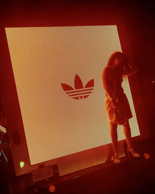A guest on a lit stage in front of the adidas trefoil at the WC26 launch